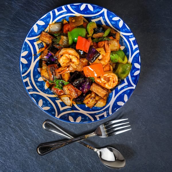 Chili Basil Thai Cuisine's shrimp and vegetable stir-fry in a blue and white patterned bowl with cutlery.