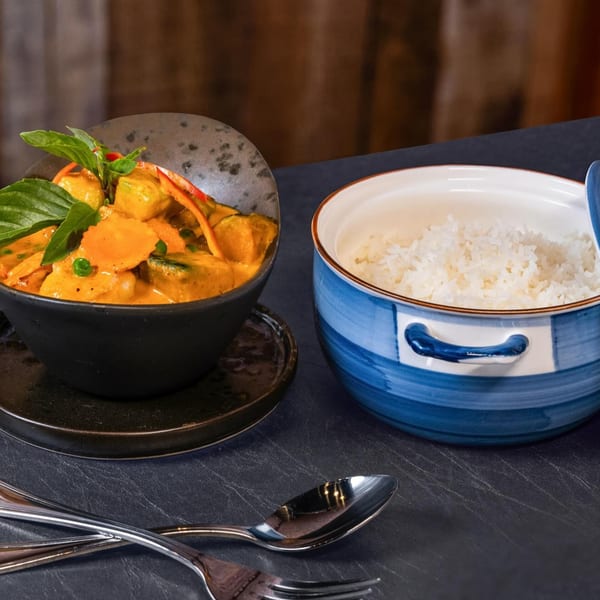 Chili Basil Thai Cuisine's red curry with vegetables and basil, served with white rice.