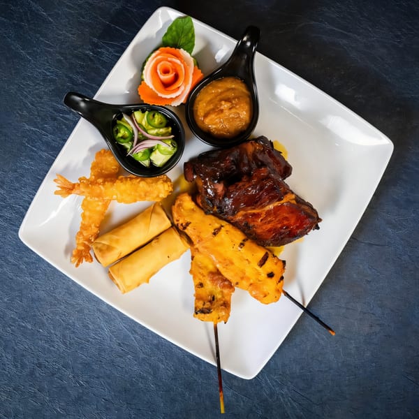 Chili Basil Thai Cuisine's appetizer platter with spring rolls, satay, fried shrimp, and ribs.