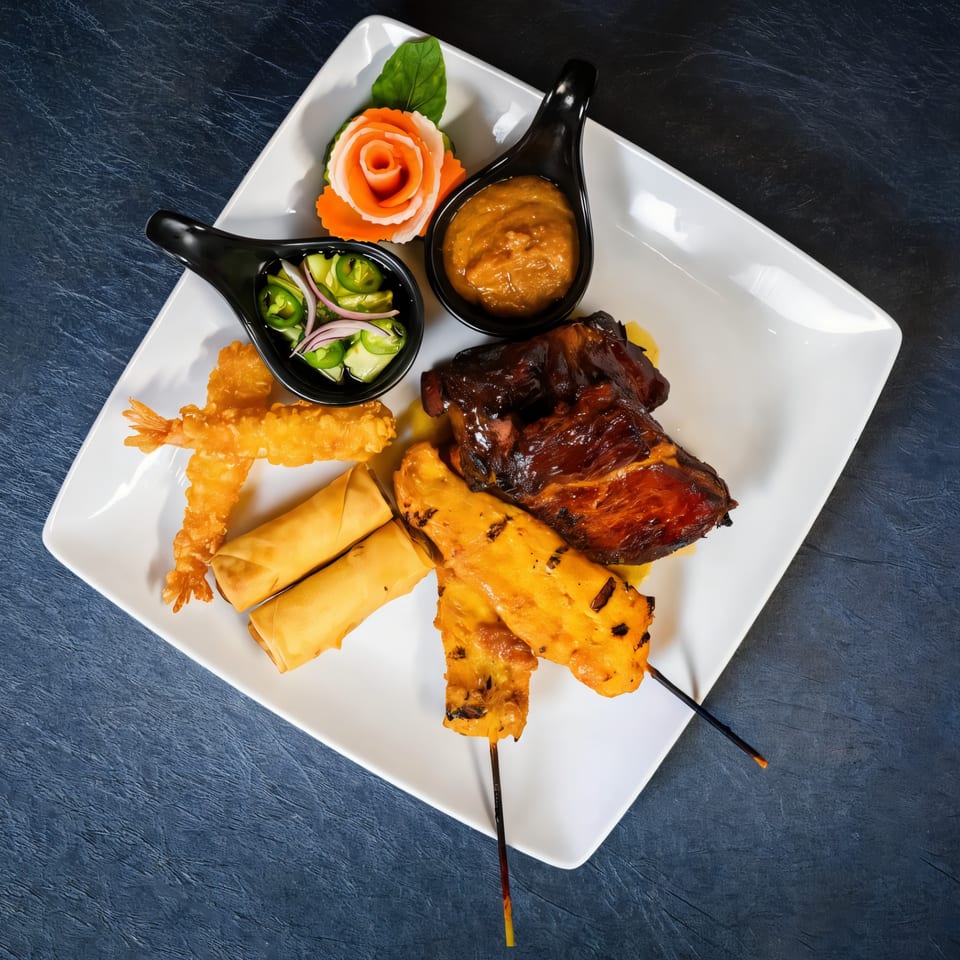 Chili Basil Thai Cuisine's appetizer platter with spring rolls, satay, fried shrimp, and ribs.